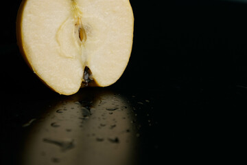 Half of apple on a black background