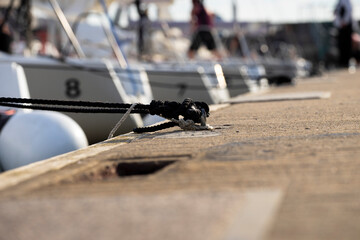 White yachts in a row moored with rope to rope from the yacht on the deck tied around Mooring at a pier moored