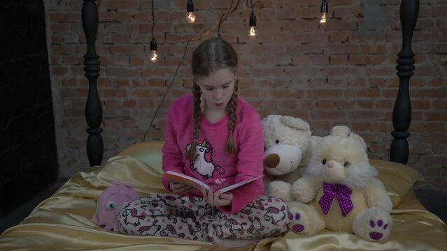 4K Young girl sitting on bed with book 