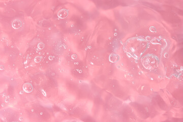 Abstract background. The texture of the waves on a pink background. Bubbling water, splashes and drops.