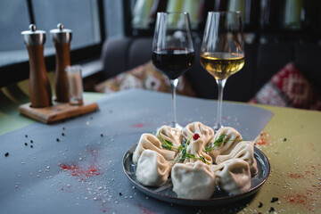 closeup of georgian khinkali with meat and wine glass on restaurant table