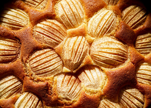 Ein fertig gebackener Apfelkuchen bei dem Zimt &uuml;ber die &Auml;pfel gestreut wurde.
