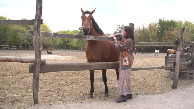 Slow Motion girl feeds a horse