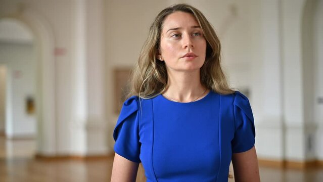 Woman wearing blue dress visiting a museum art gallery