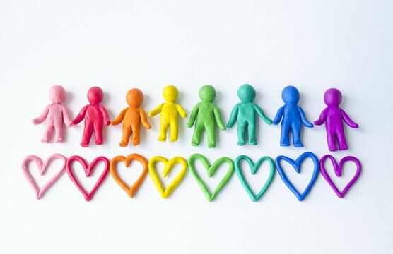 On a white isolated background, multi-colored plasticine men, a symbol of unification, friendship and love.  The concept of LGBT community, gender equality.  Banner, close-up, place for text.