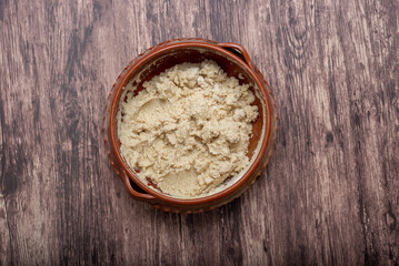 Clay pot with nixtamalized corn dough to make tortillas. Dough to prepare tortillas; typical mexican food.