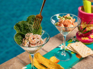 Coctel de camar&oacute;n con tajada de pl&aacute;tano y galleta de soda con fondo piscina
