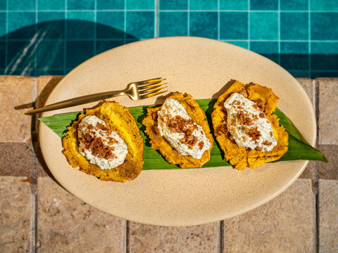 Patacones con queso y beicon con fondo piscina
