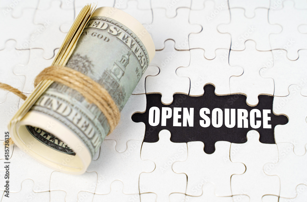 Poster Dollars lie on white puzzles, on a black surface there is an inscription - Open Source