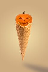 Halloween pumpkins with cone ice cream on pastel beige background. Creative idea minimal concept. Halloween sweet dessert.