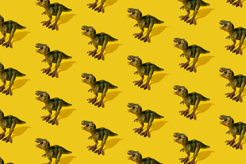 Dinosaurs Tyrannosaurus rex on a yellow background. Pattern. T-rex toy.