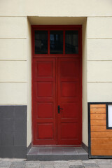 Entrance of house with beautiful red door and transom window
