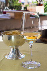 Copa de vino blanco y patatas fritas en un bar italiano