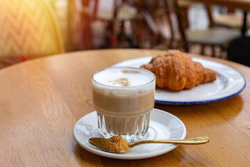 Morning breakfast, coffee latte and chocolate croissant on cafe background