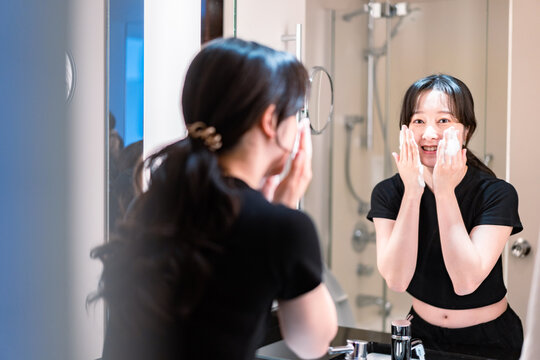 洗面所で洗顔をする若い女性