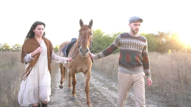 Slow Motion Loving couple in a sunny forest walking with horses