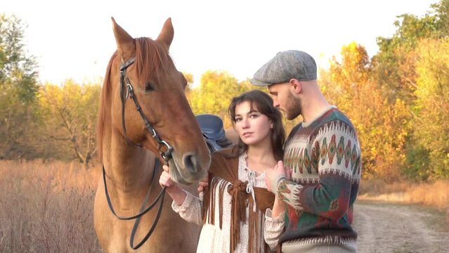 Slow Motion Romantic couple with a brown horse in the field