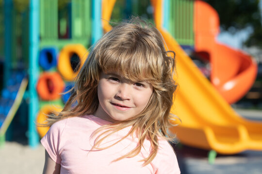 Emotional portrait of a child in the playground. Outdoor kids activity. Children playground in urban park.