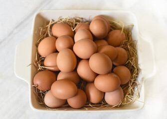 Pile of eggs on straw in a pan closeup