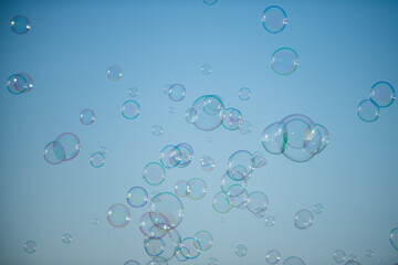 Giant colorful bubble. Big soap bubble on blue sky. Making huge rope soap bubbles.