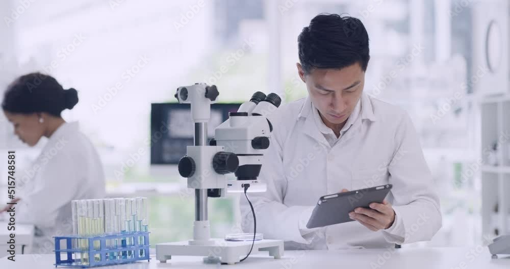 Poster Leading scientist using a microscope and digital tablet in a lab. Focused man looking at medical samples, keeping record or test results on a device. Handsome chemist discovering a cure or treatment