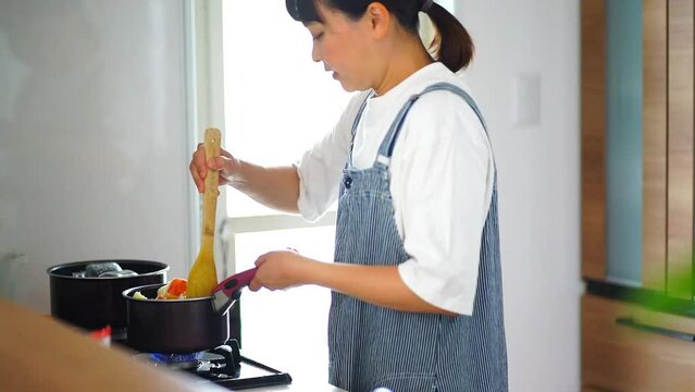 リンゴを煮詰める女性