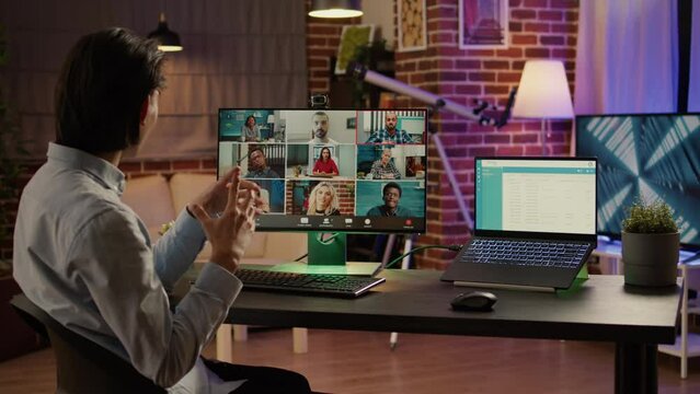 Office worker using online videoconference call on computer to talk to business colleagues at desk. Meeting on remote telework conference chat for virtual telecommunications. Handheld shot.