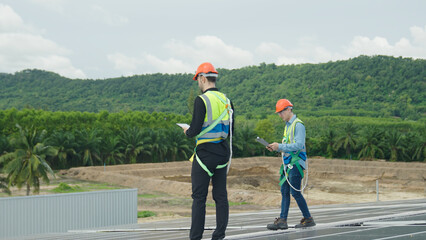 Fototapeta na wymiar Two engineers inspecting solar cell powder on factory roof