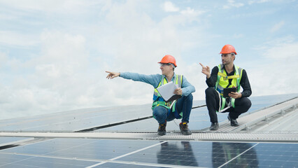 Engineer and construction worker examining solar panels on rooftop.