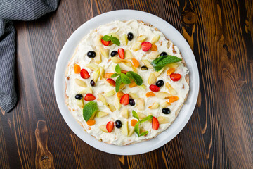 sweet pizza with fruits on plate on wooden table