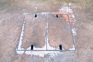 A rectangular concrete manhole cover (drainage cover,  drainage cap mortar) on the concrete street with slit