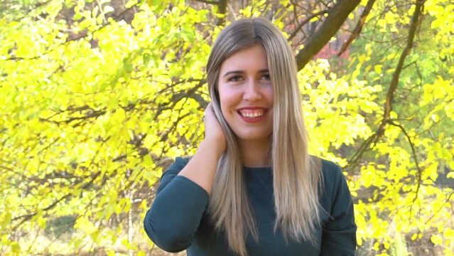 Smiling trendy woman outdoors in the city park in autumn.