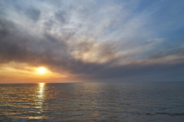 Sea sunset. Smoke wildfires sweeping across the sky.