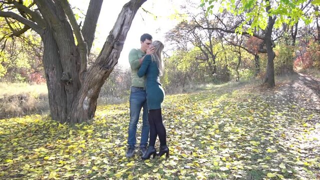 Slow Motion man and woman kissing in autumn Park
