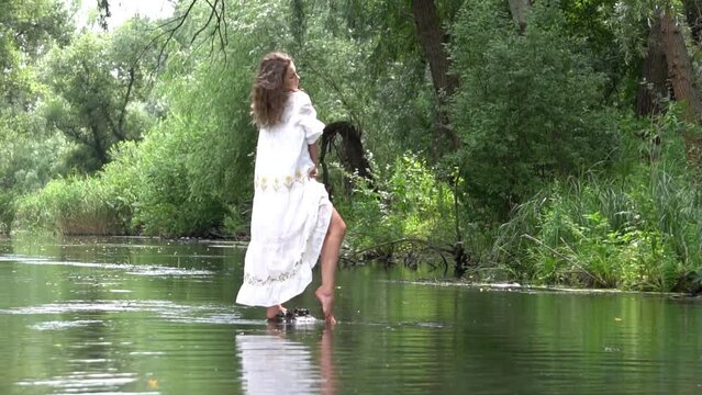 Slow Motion Beautiful girl in white dress posing in river