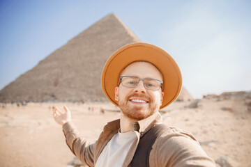 Happy tourist man in hat take selfie photo background pyramid of Egyptian , Cairo, Egypt. Concept...