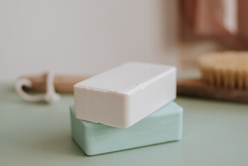 two bars of natural soap and a brush for lymphatic drainage massage in the background