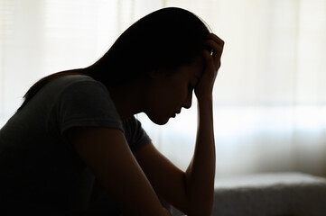 Silhouette photo of young Asian woman feeling upset, sad, unhappy or disappoint crying lonely in...