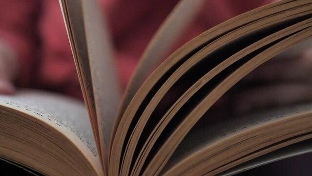 Old book pages turning in slow motion. Close up. A student reads a book searching for information and flipping pages.