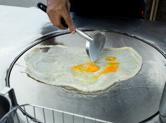 Top view of Fried delicious Roti topping with egg, focus selective