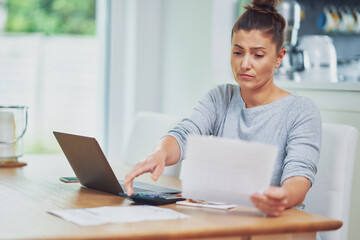 Fototapeta premium Young woman counting home budget with bills