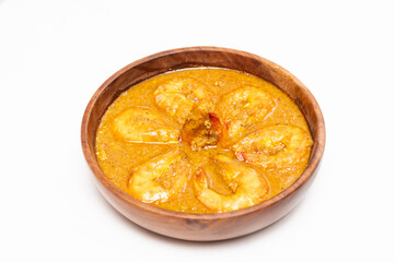 Bengali Dish or Food - Delicious authentic Bengali Prawn Malai Curry also known as chingri malai curry served on a wooden bowl. Traditional Goan Prawns or Shrimp curry. top view white background.