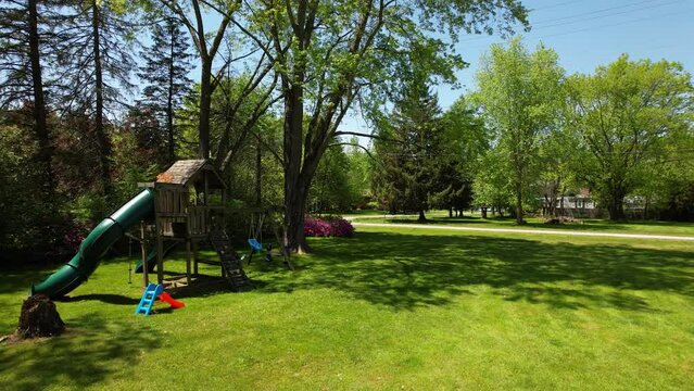 Playground with slide and swing on grass field in park