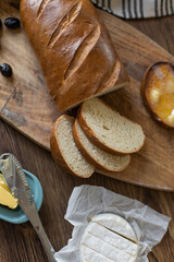 Still life on the kitchen table with baguette sliced ​​bread with butter and brie cheese.
