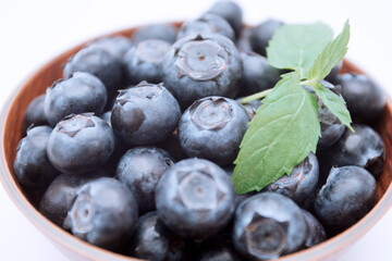 Blueberries in a bowl with a mint leaf