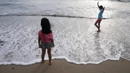 Two little girl enjoy the wave at beach - Powered by Adobe