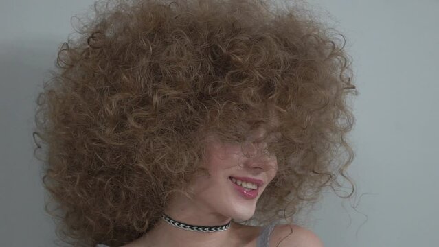 Slow Motion Portrait of pretty young blonde woman with curly hair
