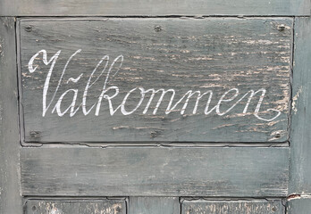 door with sign, välkommen, välkommna, swedish, svenska