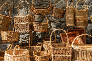 Many different wicker baskets made of natural material as background, closeup