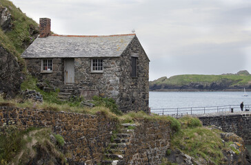 Fototapeta na wymiar The Net Loft at Mullion Cove in Cornwall is an example of an old fashioned stone, fisherman's cottage and a popular Cornish tourist attraction.
